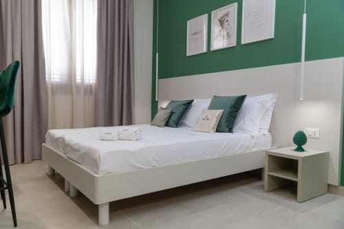 Camera moderna di Altavilla Boutique a Marsala con letto bianco, parete verde accento e arredi minimalisti