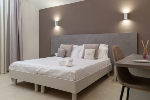 Modern bedroom in Altavilla Boutique Holidays House, Marsala with king bed, gray headboard, and contemporary furnishings