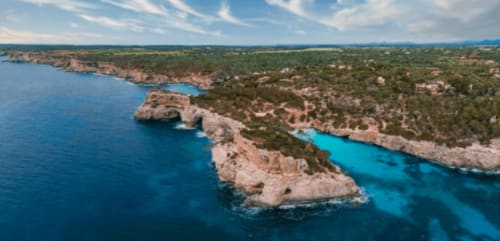 Cala turquesa y acantilados de piedra caliza en Colonia de Sant Jordi, paisaje costero de Mallorca