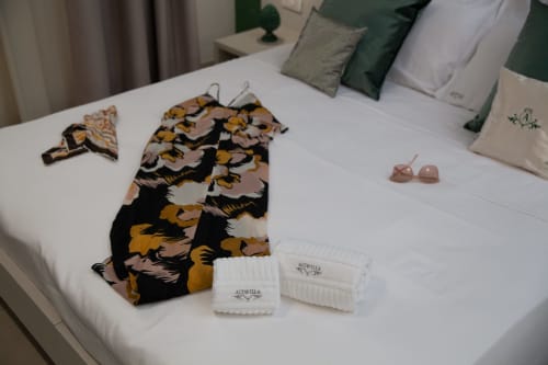 Display letto Altavilla Boutique con accappatoio decorato, asciugamani bianchi e amenità a Marsala