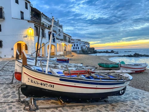 Barques de pesca a la platja al posta de sol a Palafrugell, prop de l'hotel Finques Garcia Enrich