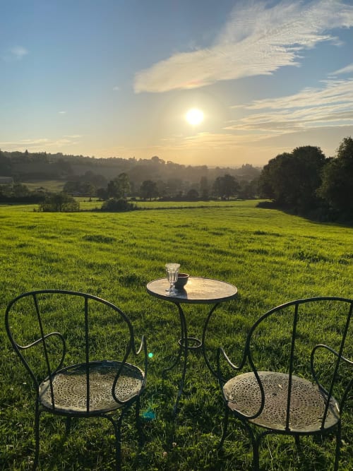 Espace de détente en plein air au Domaine de Blanvatel avec vue sur les champs verdoyants, lever de soleil et paysage champêtre à Saint Pierre en Auge