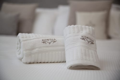 Asciugamani bianchi arrotolati con branding Altavilla presso Altavilla Boutique Holidays House a Marsala