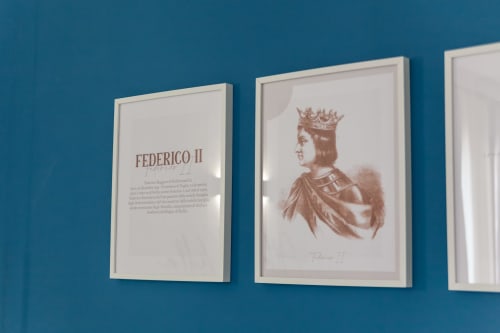 Ritratti storici incorniciati di Federico II su parete turchese nella Boutique Holidays House Altavilla a Marsala