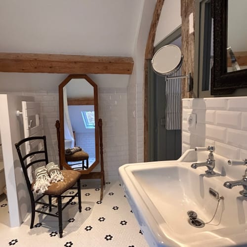 Salle de bains rustique au Domaine de Blanvalet avec double vasque, poutres apparentes et mobilier vintage