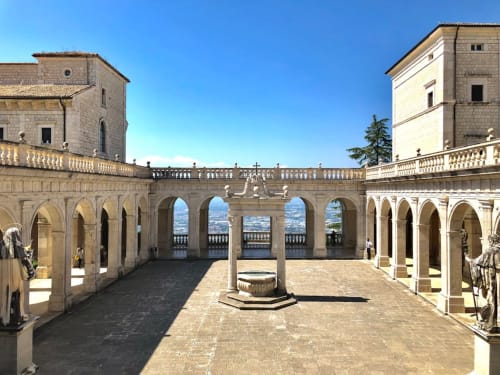 Storico cortile in pietra con colonnati presso la Casa DAF a Roccasecca, Italia, con archi e vedute sulla valle