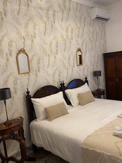 Elegante quarto duplo na pousada Patio Da Villa em Coruche, Portugal, com cama de madeira escura trabalhada e colchão de penas creme