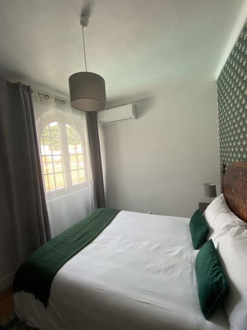 Bright bedroom at Patio Da Villa guesthouse with white bed, green accents, pendant light, and pool view window