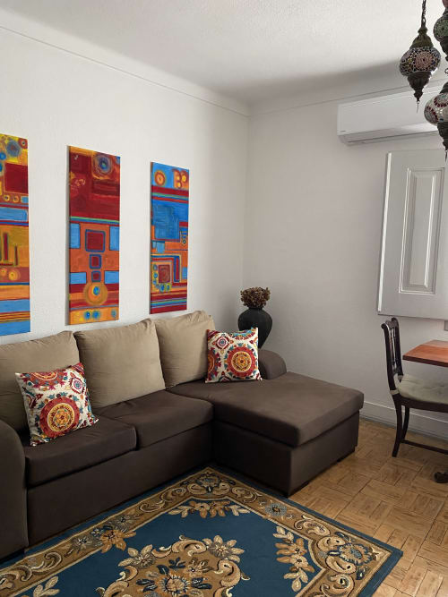 Colorful living room in Patio Da Villa Coruche guest house with dark sofa, decorative pillows, vibrant artwork, and patterned