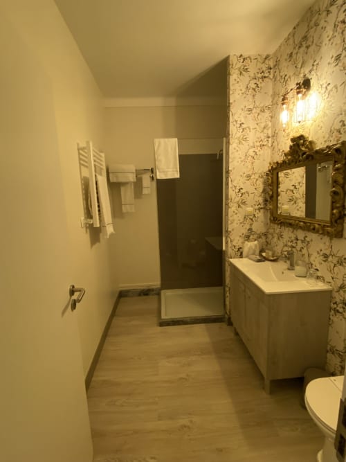 Modern bathroom in Patio Da Villa Delux Double Room, Coruche featuring floral wallpaper, white sink vanity, walk-in shower,