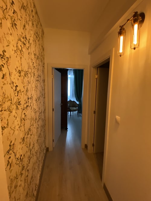 Hallway at Patio Da Villa guest house in Coruche with decorative wallpaper, pendant lights, and doors to rooms