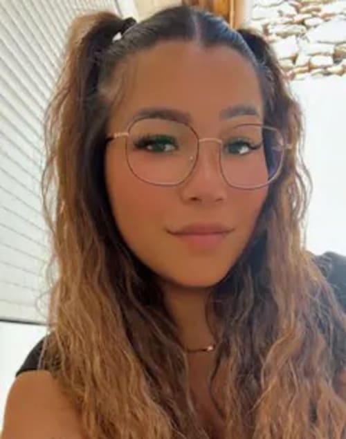 Directrice de l'hôtel La Romance à Bagard, France, portant des lunettes et souriante