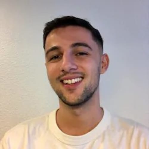 Homme souriant en t-shirt crème, directeur de l'hôtel La Romance à Bagard, France