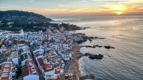 Vista de la posta de sol costanera de Palafrugell amb els seus edificis blancs i costes rocoses a Catalunya, Espanya