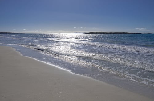 Playa de arena blanca inmaculada con olas turquesas en Colonia de Sant Jordi, España