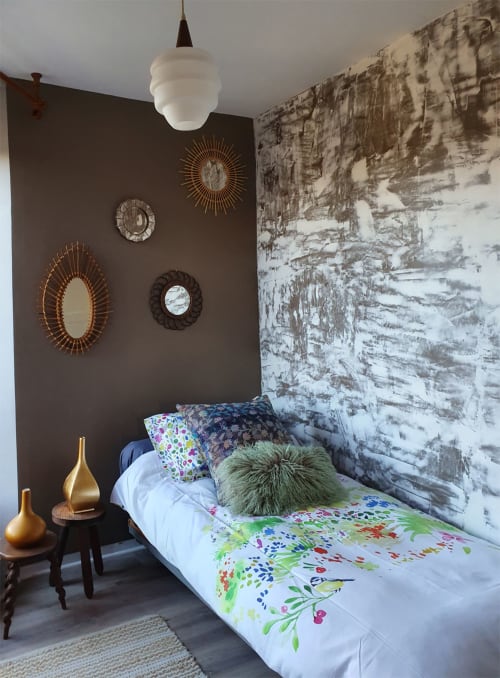 Chambre moderne aux Forges Du Lou avec miroirs décoratifs sur mur d'accent sombre, papier peint bouleau et literie colorée
