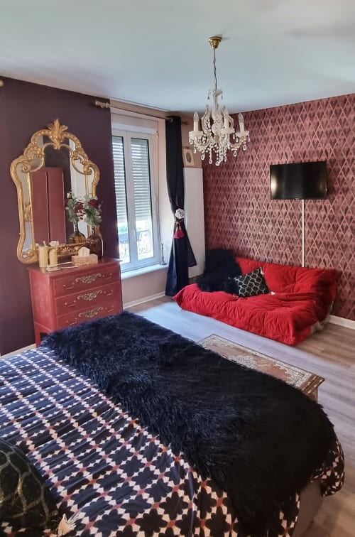Suite élégante aux Forges Du Lou B&B à Jugon-les-Lacs avec canapé en velours rouge, papier peint damas bordeaux, or ouvragé