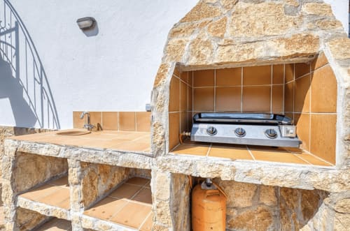 Outdoor kitchen setup with gas grill and sink at Finques Garcia Enrich cottage in Palafrugell, near beach