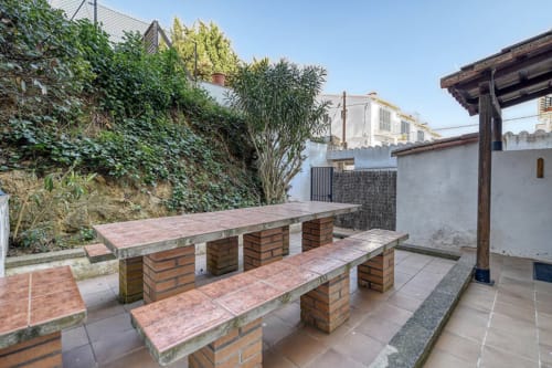 Outdoor patio with brick picnic table and benches at Finques Garcia Enrich apartment in Palafrugell