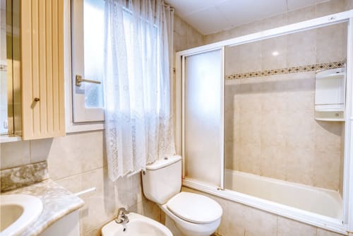 Modern bathroom in Palafrugell apartment with shower, toilet, sink, and heated towel rack