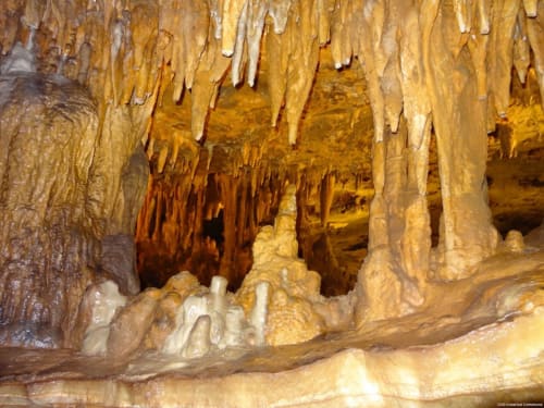 Formations de stalactites et stalagmites dans une galerie souterraine dorée près de Bagard, France