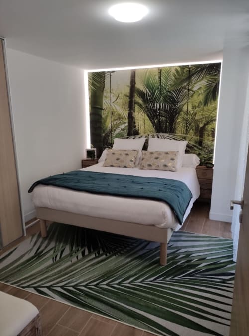  "Chambre de l'appartement à Vars-les-Claux, décorée avec un papier peint tropical au motif de palmiers verts, offrant une atmosphère à la fois fraîche et apaisante pour un séjour reposant."