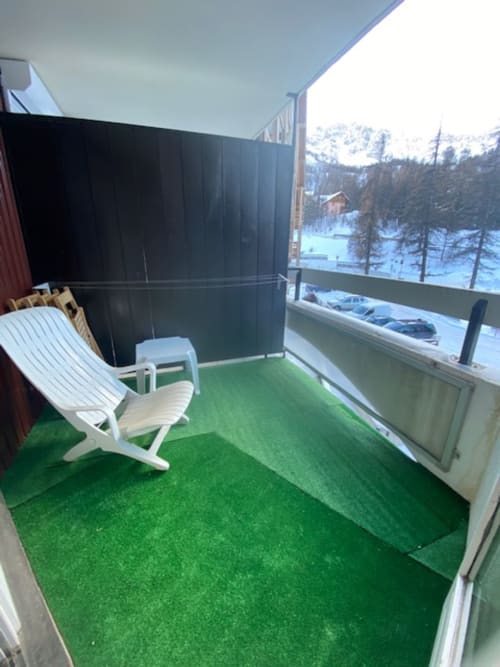  "Balcon de l'appartement 669 à Vars-les-Claux, avec sol en faux gazon et vue panoramique sur le massif de l'Eyssina, parfait pour profiter d'un moment de détente face aux montagnes."