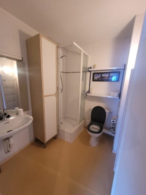  "Salle de bain fonctionnelle de l'appartement 554 à Vars-les-Claux, équipée de toilettes et d'une douche moderne, offrant un espace pratique et confortable pour se détendre après une journée sur les pistes."