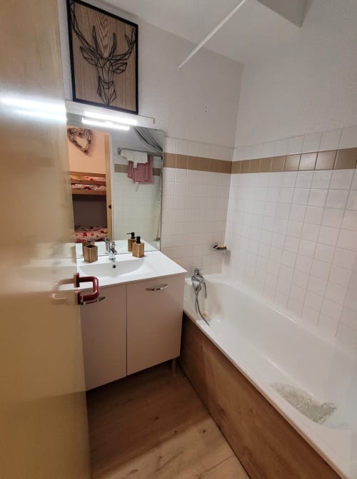 Salle de bain de l'appartement à Vars-les-Claux, équipée d'une baignoire spacieuse, idéale pour se détendre après une journée sur les pistes, avec des finitions modernes et un décor soigné."