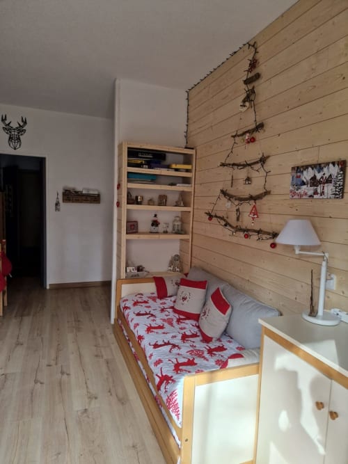 "Vue du salon et de la cuisine de l'appartement à Vars-les-Claux, décorés dans les couleurs de Noël, créant une ambiance festive et chaleureuse, idéale pour profiter de moments conviviaux en famille ou entre amis après une journée de ski."