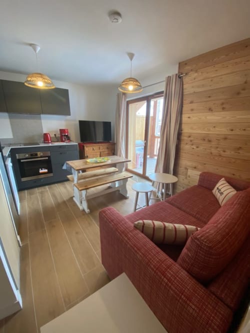 "Salon de l'appartement 405B à Vars-les-Claux, décoré dans un style chic anglais, avec des meubles élégants, des couleurs raffinées et une ambiance cosy, idéale pour se détendre après une journée à la montagne."