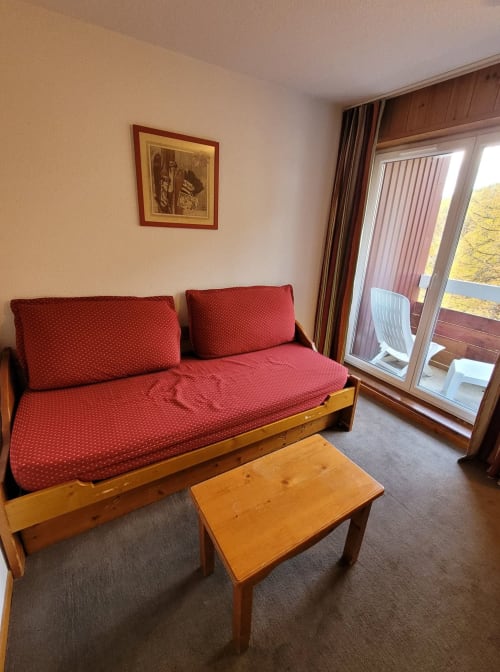 "Salon de l'appartement 701 à Vars-les-Claux, aménagé avec un canapé confortable et une table basse élégante, offrant un espace convivial et chaleureux pour se détendre après une journée sur les pistes."
