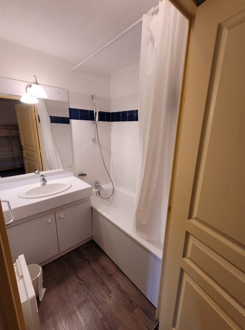 "Salle de bain moderne de l'appartement 701 à Vars-les-Claux, équipée d'une douche spacieuse et de finitions élégantes, offrant un espace pratique et relaxant pour se ressourcer après une journée de ski."
