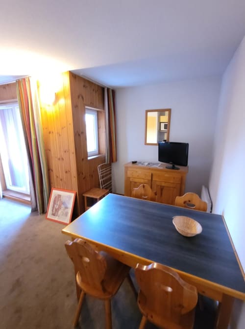 "Salon de l'appartement 701 à Vars-les-Claux, comprenant un espace repas avec une table à manger conviviale, idéal pour partager des repas en famille ou entre amis dans une ambiance chaleureuse après une journée en montagne."