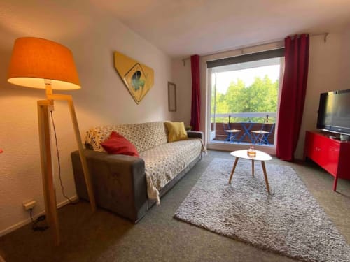 "Vue du salon et du balcon de l'appartement 776 à Vars-les-Claux, offrant un espace lumineux avec accès direct à l'extérieur, idéal pour profiter du paysage montagnard depuis le confort du salon."