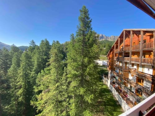 Vue depuis le balcon de l'appartement 776 à Vars-les-Claux, donnant sur les mélèzes majestueux, offrant un cadre naturel et apaisant pour apprécier la beauté de la forêt alpine en toute saison."