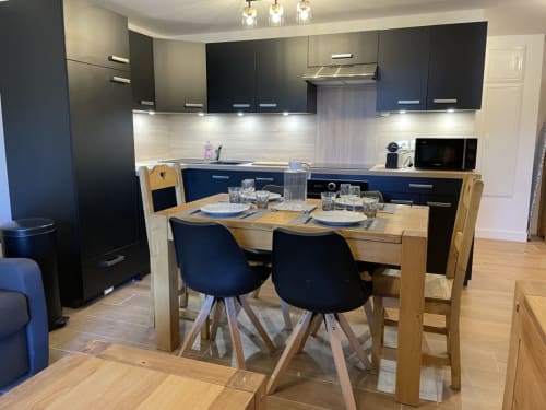 "Cuisine noire chic de l'appartement 203 à Vars-les-Claux, avec des finitions élégantes et des équipements modernes, offrant un espace sophistiqué et fonctionnel pour préparer des repas après une journée de ski."
