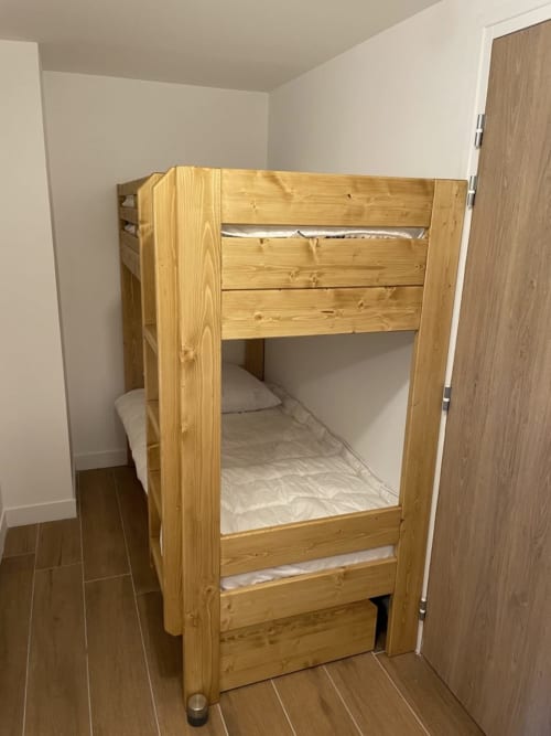 "Coin nuit de l'appartement 203 à Vars-les-Claux, équipé de lits superposés, offrant un espace fonctionnel et cosy, idéal pour les enfants ou les amis durant un séjour à la montagne."