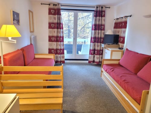 "Salon de l'appartement à Vars-les-Claux, avec une vue dégagée sur le balcon, offrant un espace confortable et lumineux, idéal pour se détendre tout en profitant de la vue sur les montagnes."