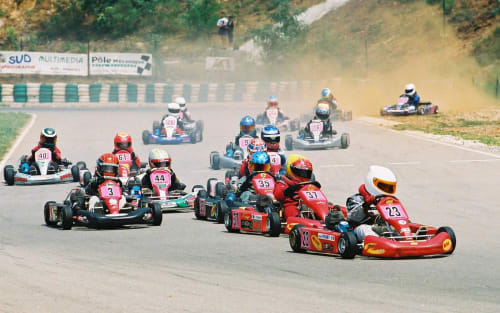 Événement de course de karts sur le circuit de Bagard avec plusieurs karts rouges et colorés en compétition sur piste