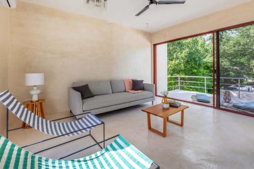 Sala moderna de Casa tuch BnB en Mérida con sillones rayados, sofá gris y acceso a terraza