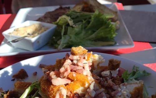  "Salade César copieuse servie au restaurant La Marmotte à Vars-les-Claux, composée de laitue fraîche, poulet grillé, croûtons et parmesan, idéale pour un repas savoureux après une journée de ski."