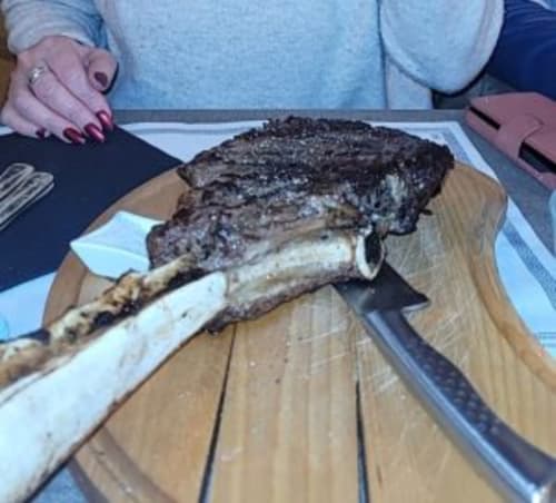 "Pièce de bœuf Tomahawk grillée, spécialité carnivore à déguster à Vars Les Claux."