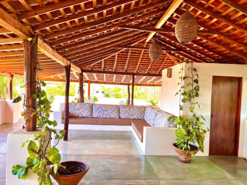 Lounge al aire libre de Calilla & Tsuki en Puerto Escondido con techo de madera, cómodos asientos y plantas exuberantes
