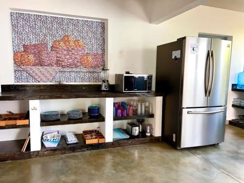 Cocina moderna del hotel Calilla & Tsuki en Puerto Escondido con electrodomésticos de acero inoxidable y decoración artística en las paredes