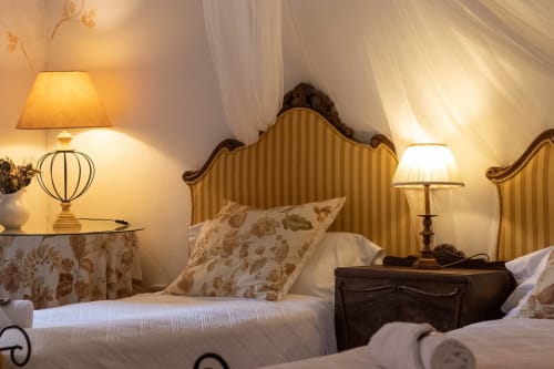 Elegant bedroom at Casa Peregrinando in Navarrete with ornate headboards, warm lighting, and classic decor