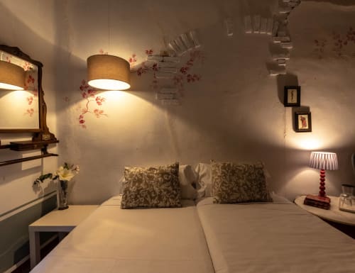 Chambre douillette à Casa Peregrinando à Navarrete avec lits jumeaux, coussins décoratives, lampe suspendue et éclairage ambiant chaleureux