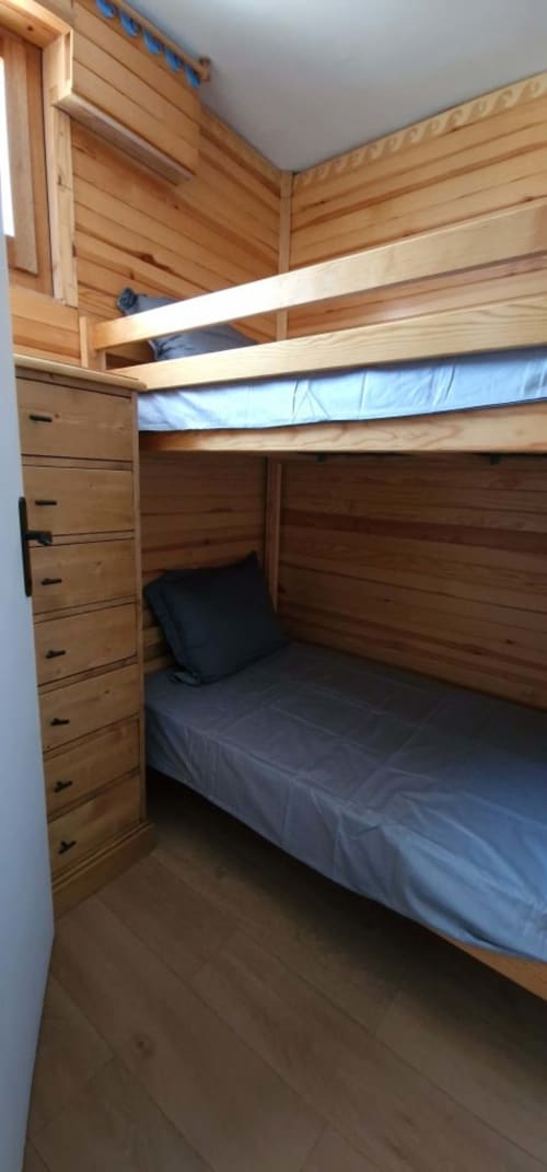 "Coin nuit en bois de l'appartement à Vars-les-Claux, offrant un espace cosy et naturel avec des finitions en bois chaleureux, idéal pour une bonne nuit de repos après une journée de ski."