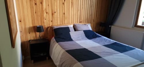 "Chambre de l'appartement à Vars-les-Claux, aménagée avec un lit double confortable, créant un espace paisible et chaleureux pour une bonne nuit de sommeil après une journée sur les pistes."