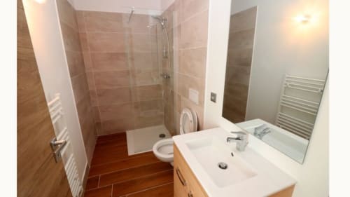 Salle d'eau de l'appartement à Vars-les-Claux, équipée d'une douche moderne et de toilettes, offrant un espace fonctionnel et pratique pour se rafraîchir après une journée sur les pistes.